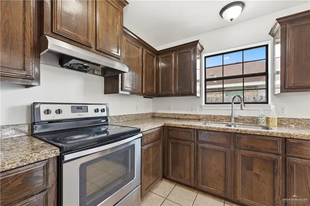 a kitchen with stainless steel appliances granite countertop a sink stove and cabinets