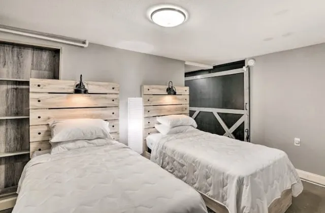 a bedroom with two beds and a refrigerator