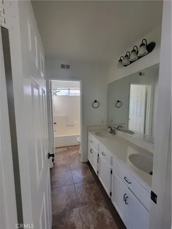 a bathroom with a double vanity sink mirror and shower