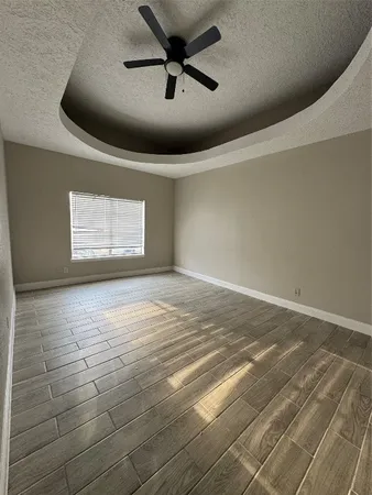 en empty room with windows and ceiling fan