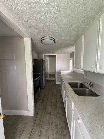 a kitchen with granite countertop a sink and cabinets