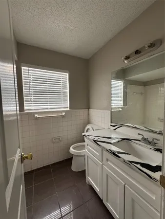 a view of a bathroom with a sink a toilet and a window