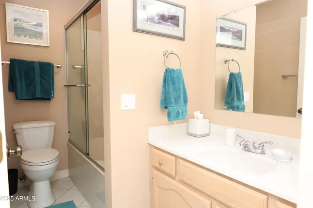 a bathroom with a granite countertop sink and a toilet