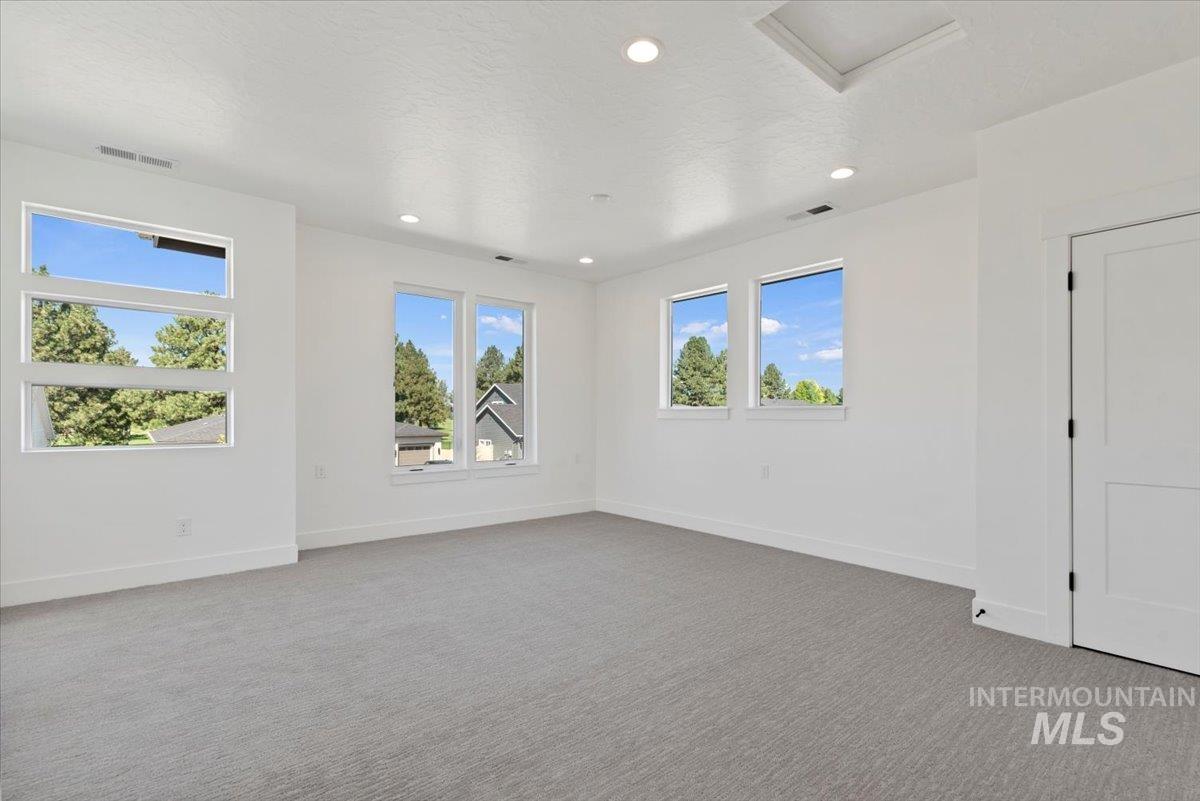677 North Morning Glory Way Eagle, ID 83616 - Photo 13 of 29 Unfurnished room with light colored carpet, recessed lighting, and a textured ceiling