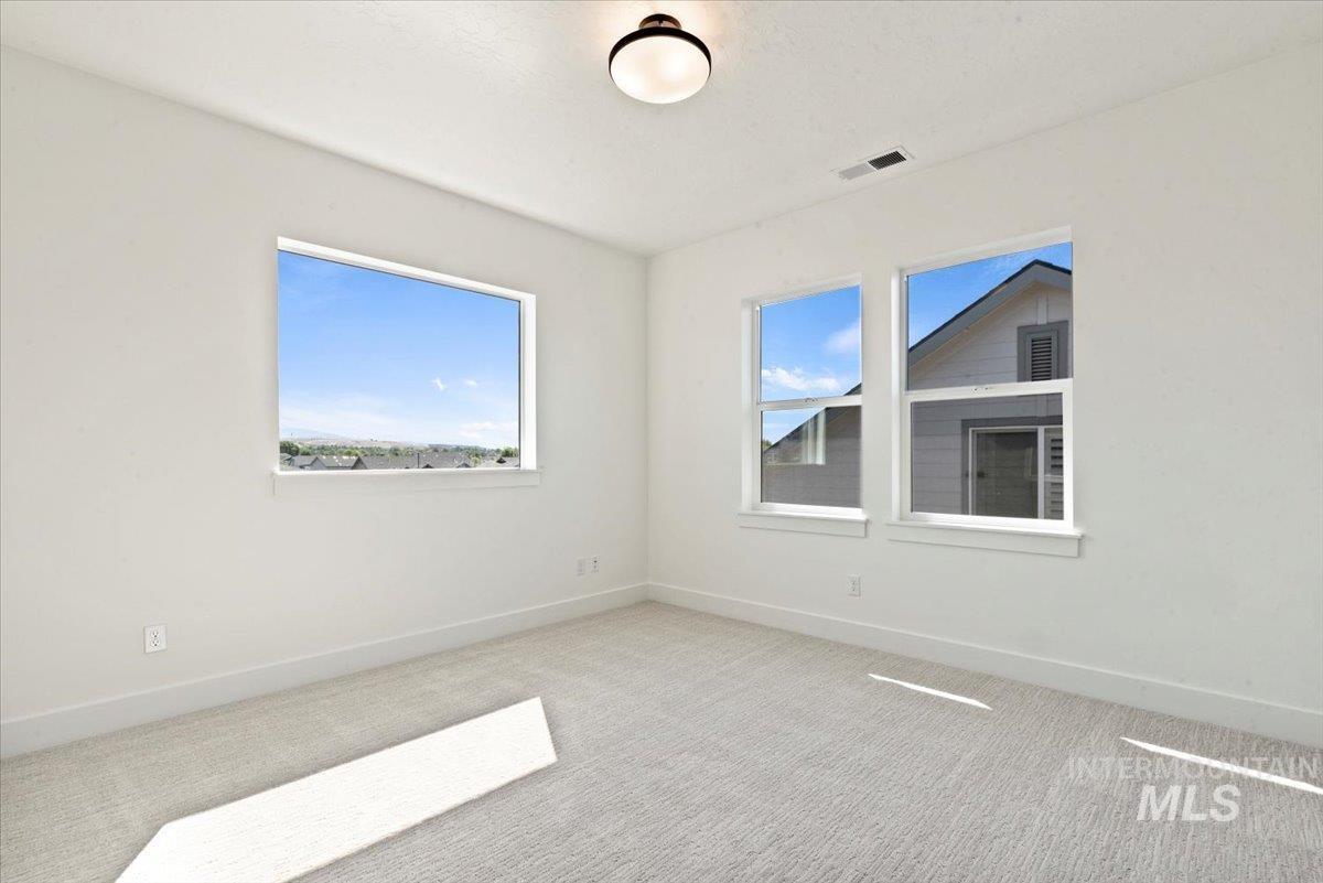 677 North Morning Glory Way Eagle, ID 83616 - Photo 14 of 29 Carpeted spare room featuring healthy amount of natural light