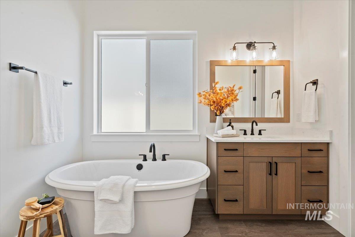 677 North Morning Glory Way Eagle, ID 83616 - Photo 19 of 29 Full bath featuring vanity, a soaking tub, and dark wood-style floors