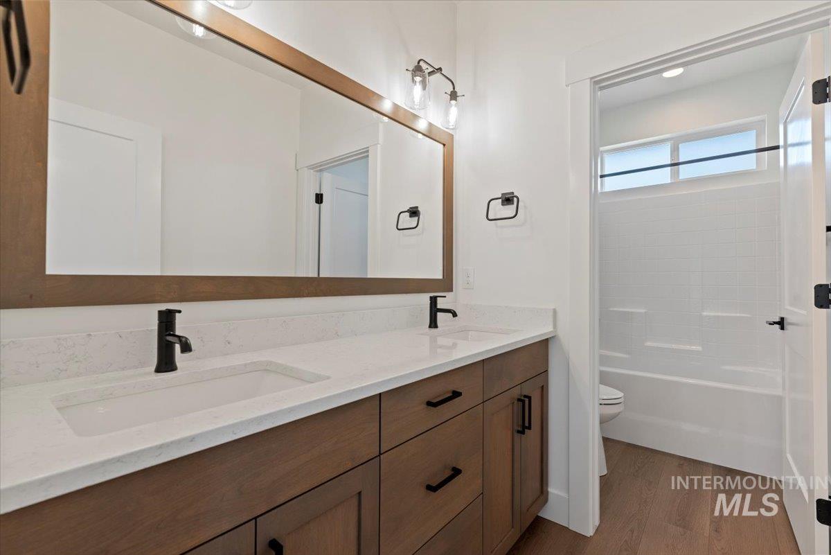 677 North Morning Glory Way Eagle, ID 83616 - Photo 22 of 29 Bathroom with double vanity, dark wood-type flooring, and shower / bath combination