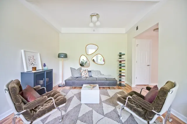 a living room with furniture and a mirror