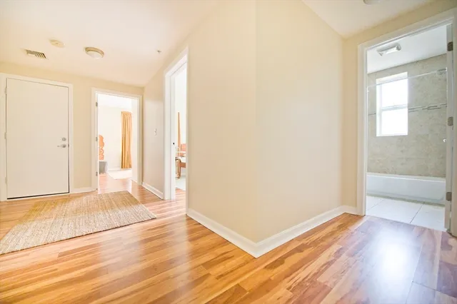 a view of a room with wooden floor and a bathroom