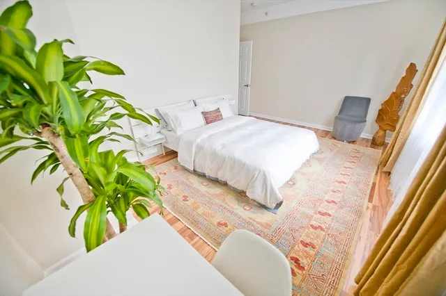 a spacious bedroom with a bed and a rug