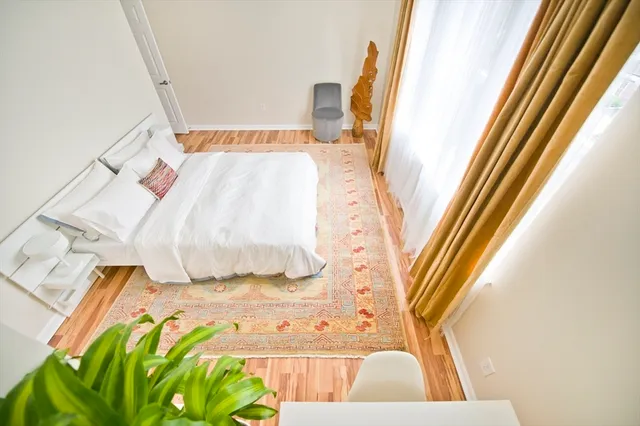 a view of walk in closet with rug and wooden floor