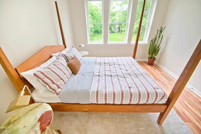 a bed sitting in a bedroom next to a window