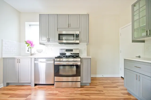 a kitchen with stainless steel appliances granite countertop a stove microwave and sink