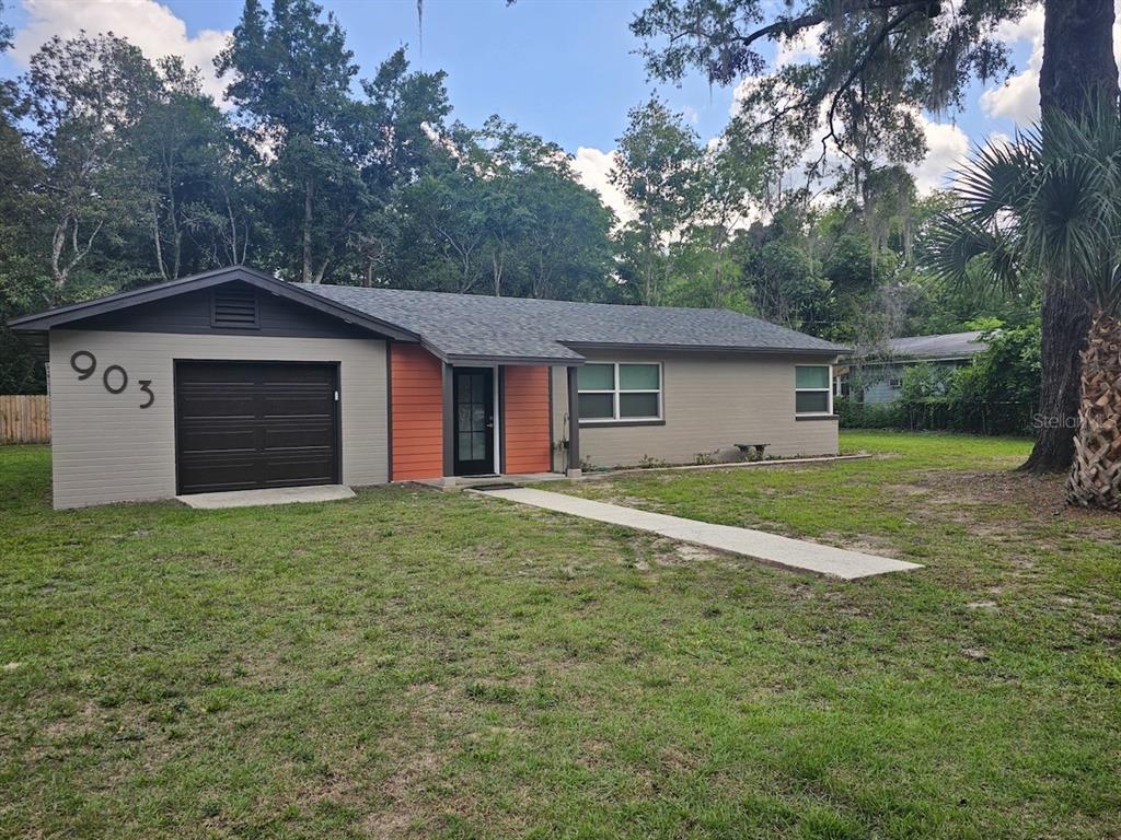903 Northwest 33rd Avenue Gainesville, FL 32609 - Photo 1 of 23 a house with huge green field in front of it