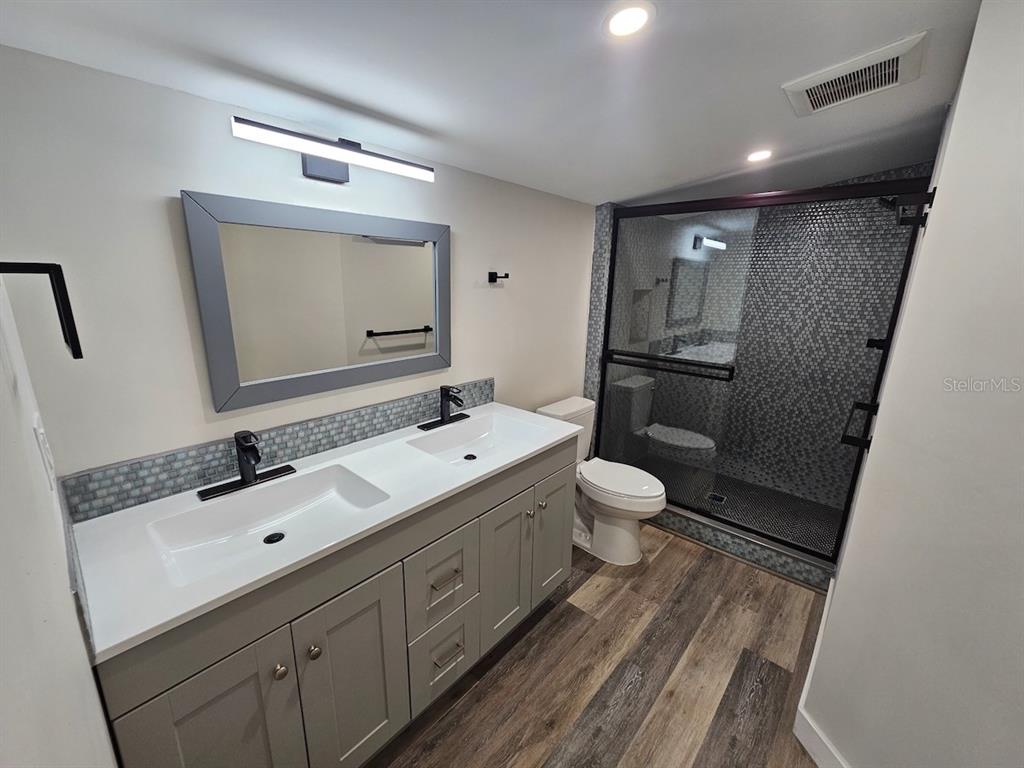 903 Northwest 33rd Avenue Gainesville, FL 32609 - Photo 11 of 23 a bathroom with a double vanity sink and mirror with toilet