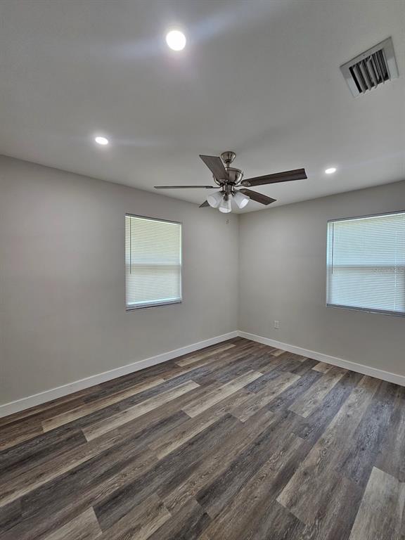 903 Northwest 33rd Avenue Gainesville, FL 32609 - Photo 15 of 23 an empty room with wooden floor fan and windows