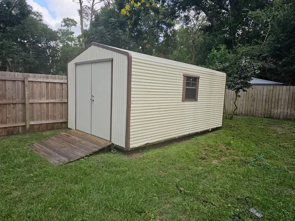 a view of backyard of house with wooden fence