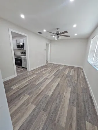 wooden floor in an empty room with a kitchen