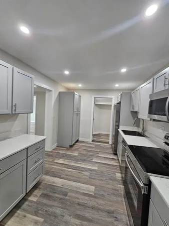 a large kitchen with kitchen island a sink stainless steel appliances and cabinets