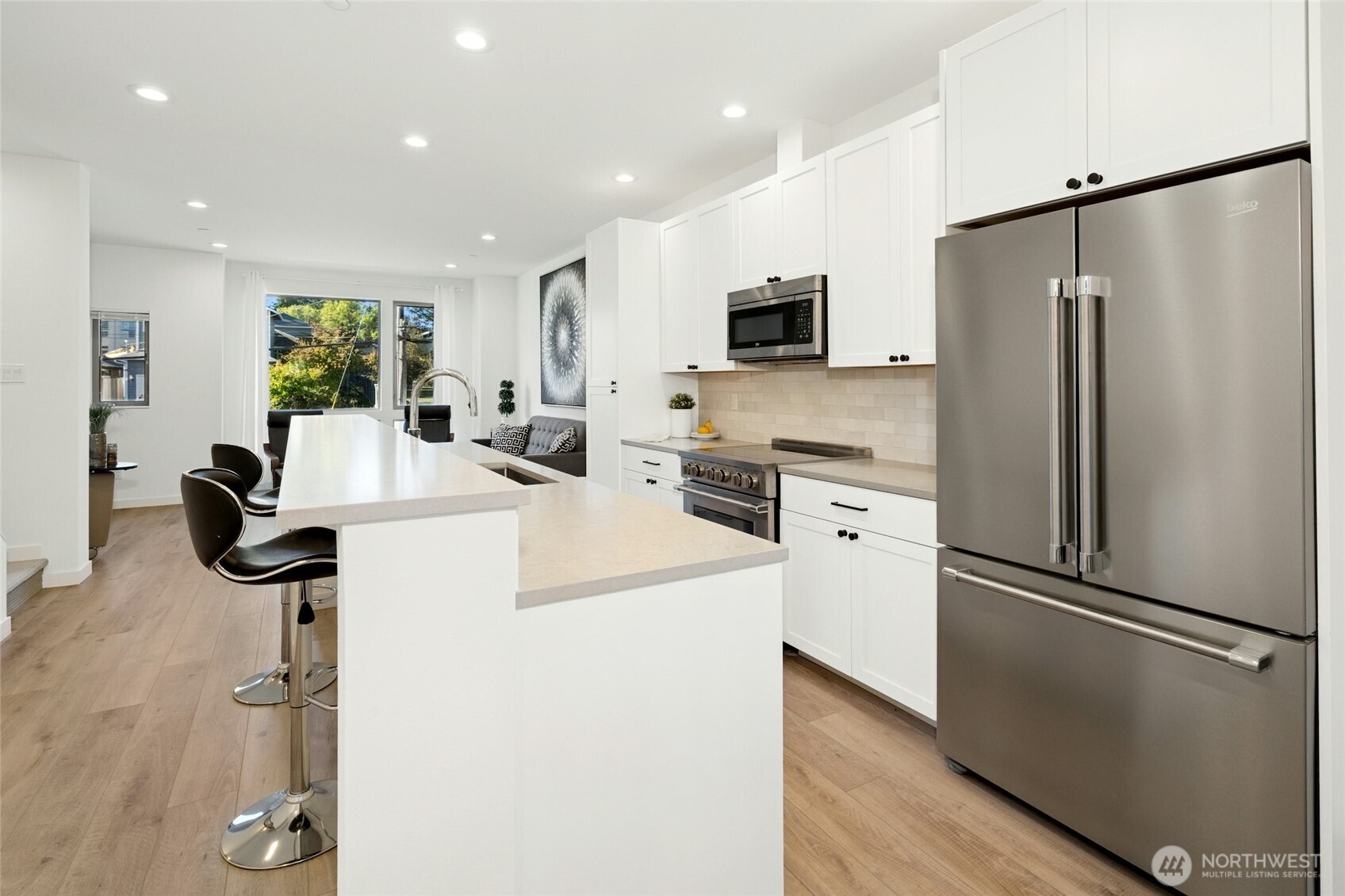 18512 Wallingford Avenue North Shoreline, WA 98133 - Photo 10 of 32 a kitchen with white cabinets and stainless steel appliances