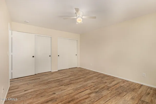 a view of a room with wooden floor and a ceiling fan