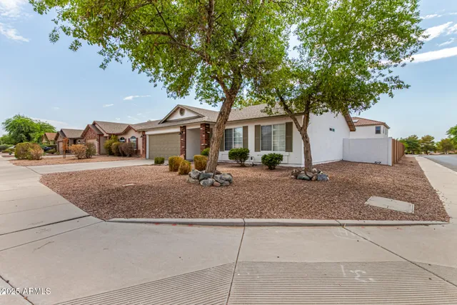 a front view of a house with a yard and trees