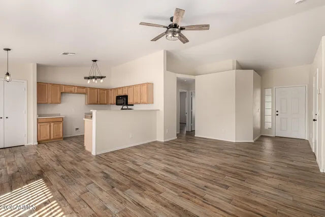 a view of a kitchen with a sink and dishwasher a refrigerator with wooden floor