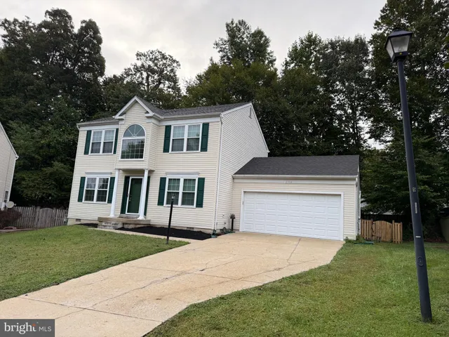 a front view of a house with a yard and trees