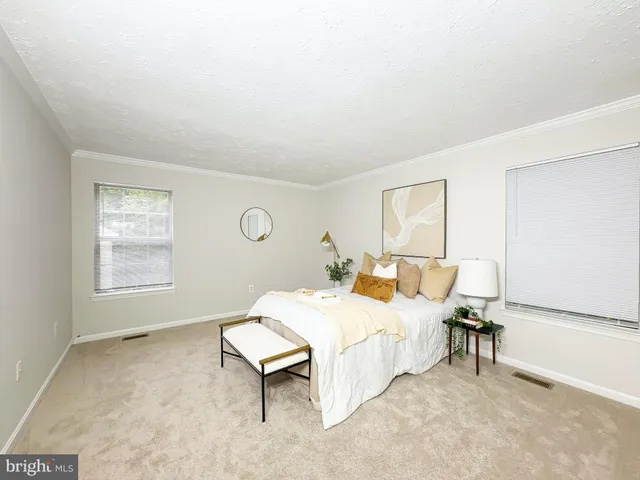 a bedroom with a bed table chair and a window