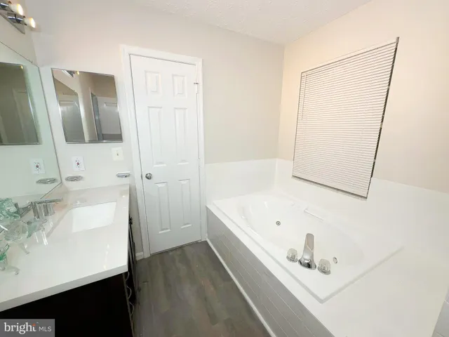 a bathroom with a bathtub sink and mirror