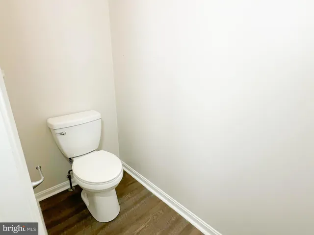 a white toilet sitting next to a white wall