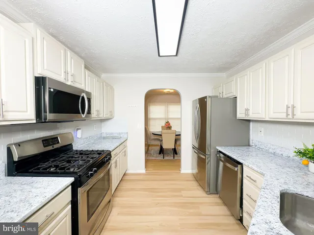 a kitchen with stainless steel appliances granite countertop a stove refrigerator sink and microwave