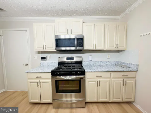 a kitchen with white cabinets and black appliances