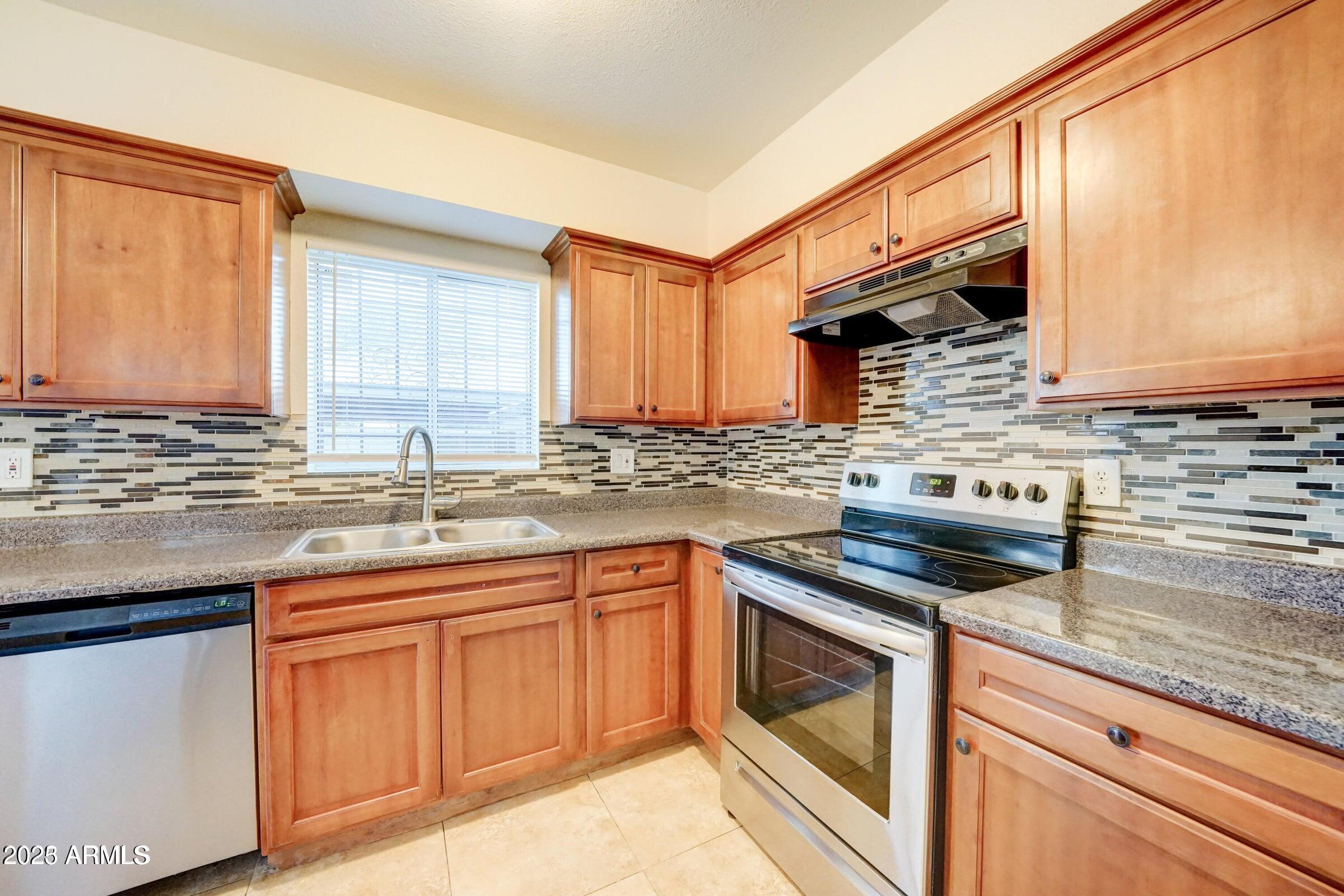 3605 West Bethany Home Road, Unit 17 Phoenix, AZ 85019 - Photo 5 of 13 a kitchen with stainless steel appliances granite countertop a sink stove and cabinets