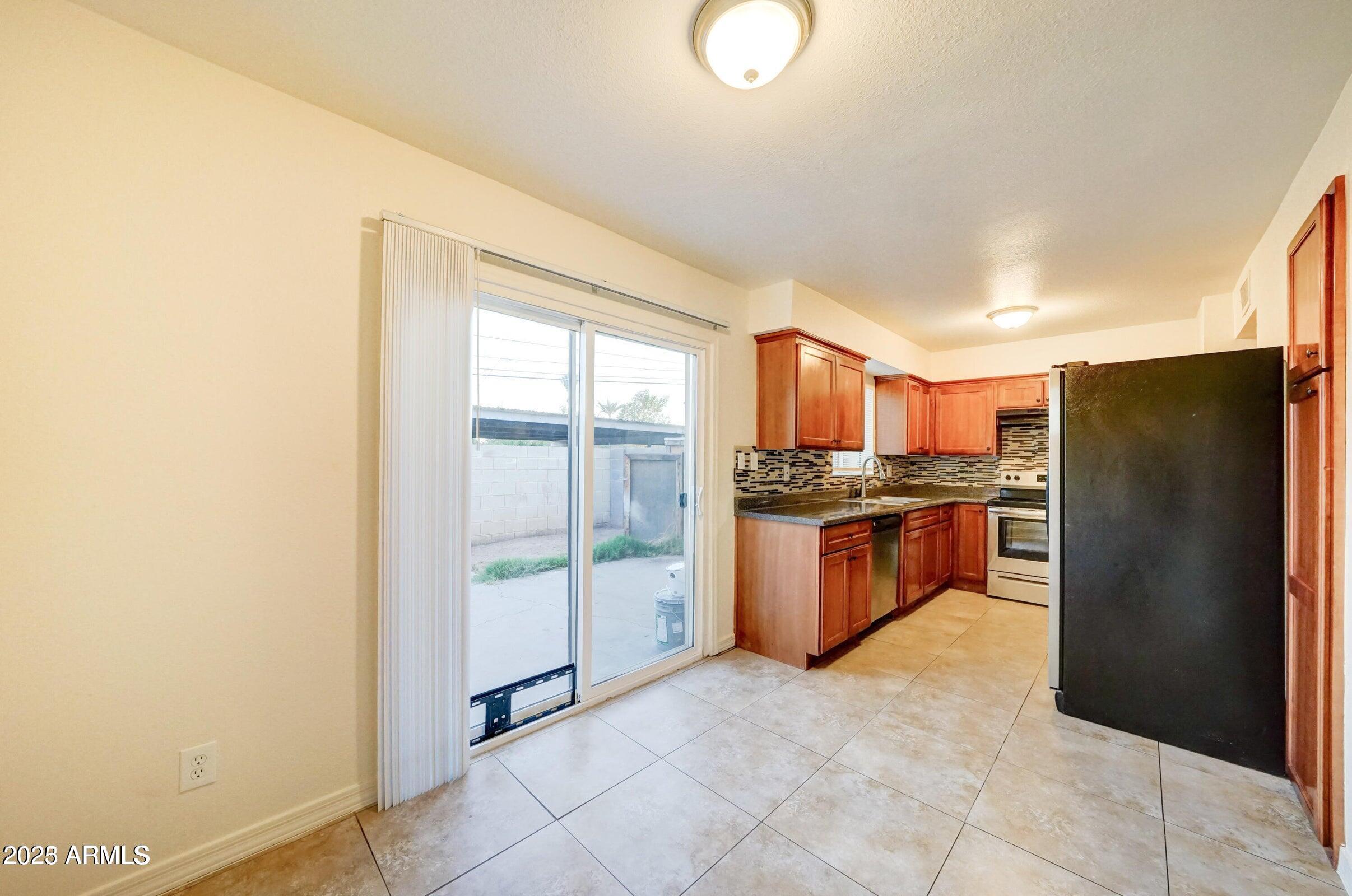 3605 West Bethany Home Road, Unit 17 Phoenix, AZ 85019 - Photo 8 of 13 a kitchen with stainless steel appliances granite countertop a refrigerator and a stove