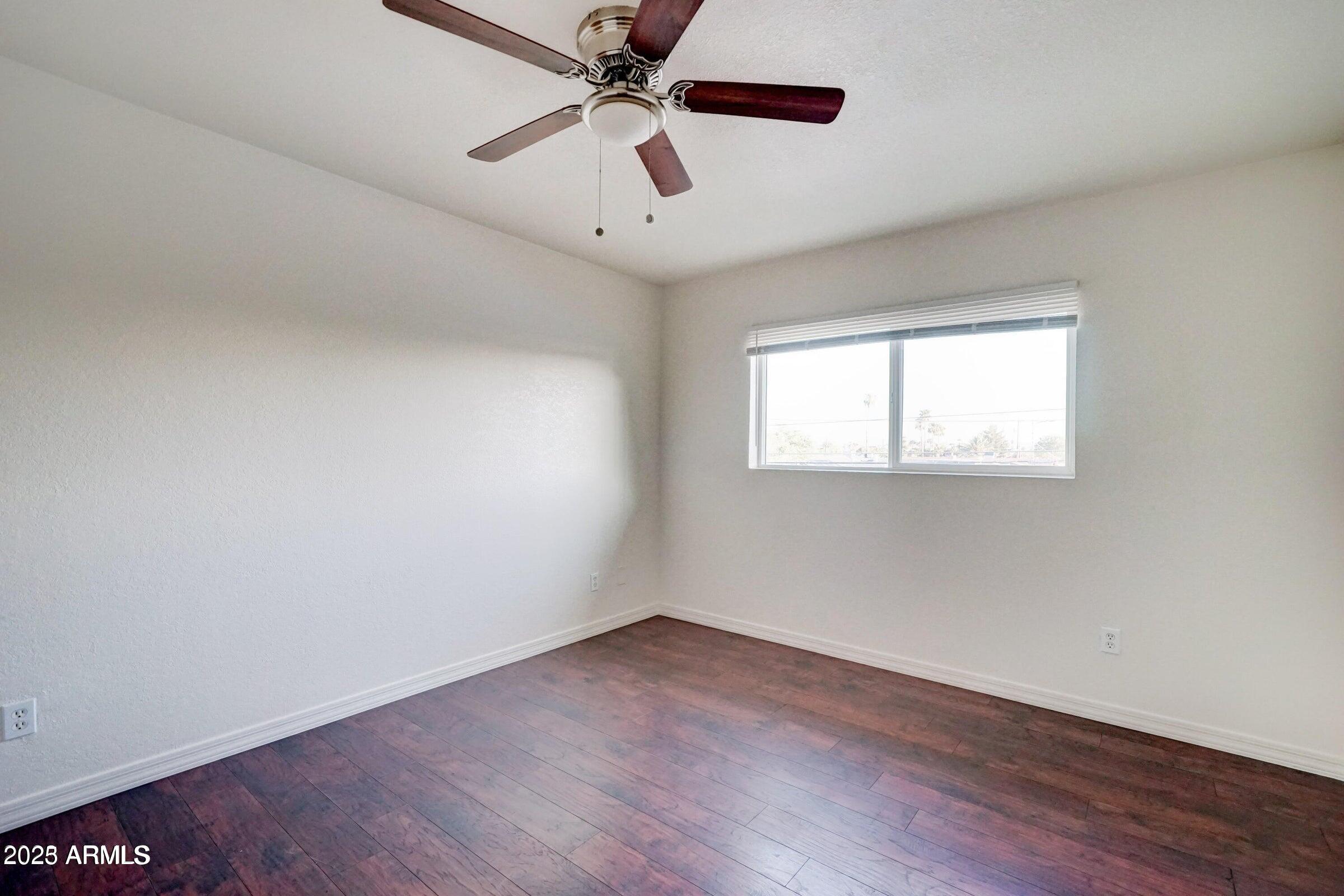 3605 West Bethany Home Road, Unit 17 Phoenix, AZ 85019 - Photo 9 of 13 wooden floor in an empty room with a window