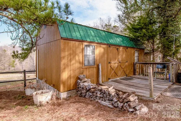 a view of a barn with a table and chairs under an umbrella