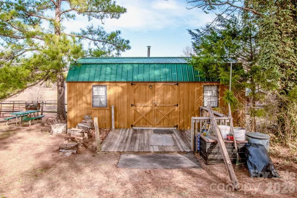 a view of backyard with small cabin and wooden fence