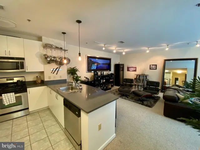 a kitchen with stainless steel appliances granite countertop a sink a stove and a refrigerator