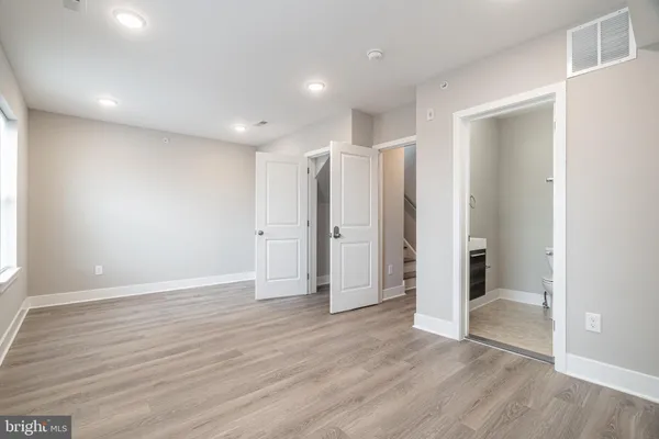 a view of an empty room with wooden floor
