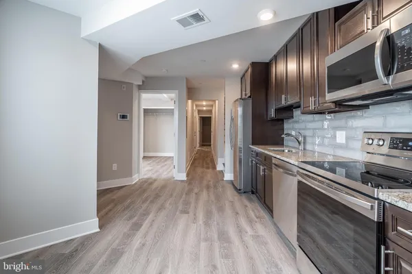 a kitchen with stainless steel appliances granite countertop a stove a sink and a refrigerator