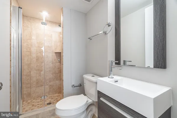 a bathroom with a sink a toilet and shower