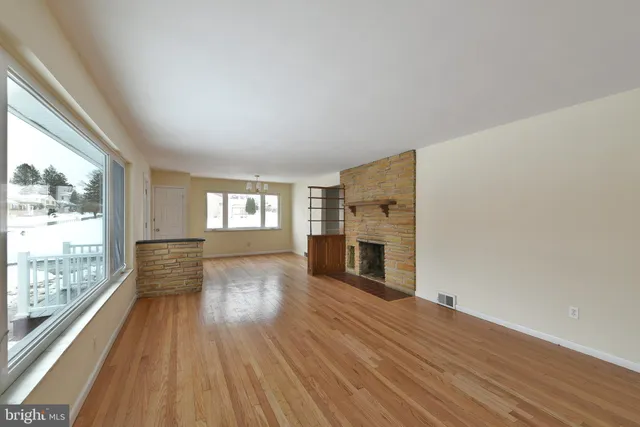 a view of empty room with wooden floor and fireplace