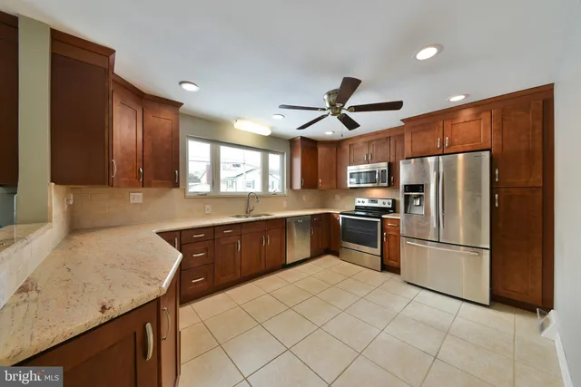 a kitchen with stainless steel appliances granite countertop a refrigerator a sink a stove a microwave and island