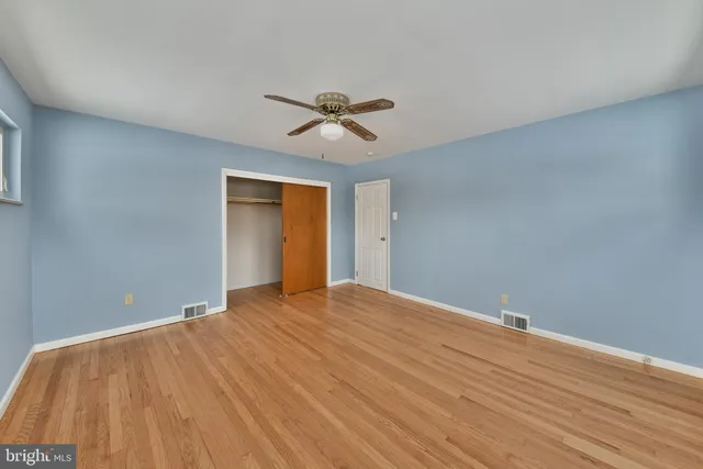 a view of a big room with wooden floor and windows
