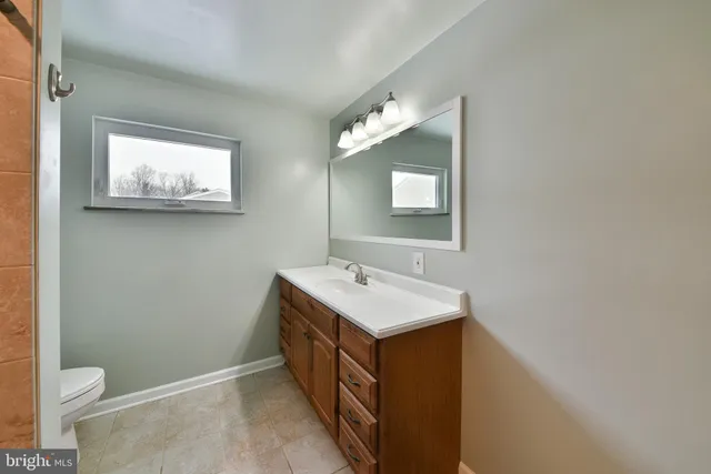 a bathroom with a toilet sink and mirror