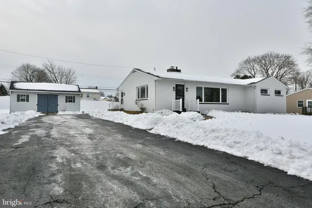 a large white house with a yard covered in snow