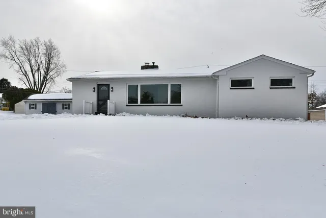 a front view of house with yard and trees in the background
