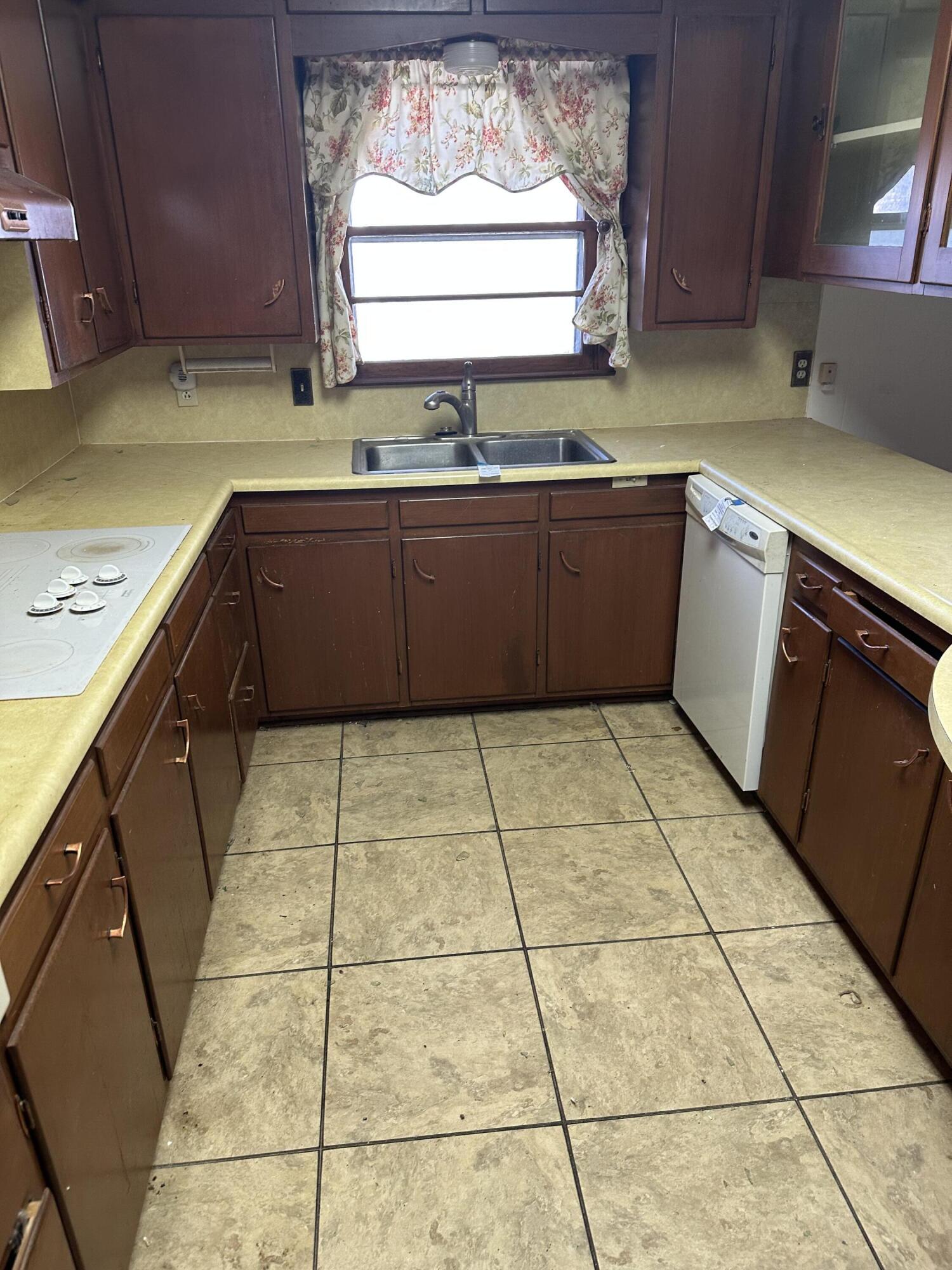 600 Southwest Ave J Seminole, TX 79360 - Photo 19 of 27 a kitchen with a sink a stove a microwave and cabinets