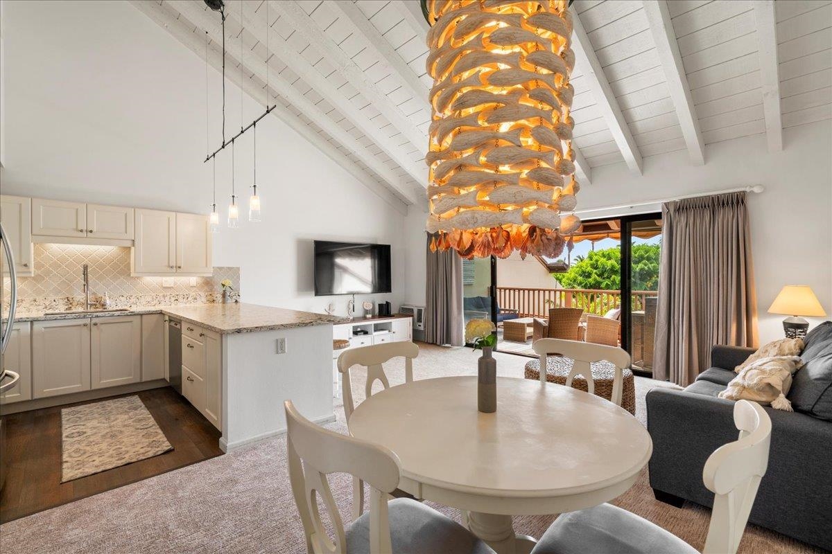 2777 South Kihei Road, Unit F203 Kihei, HI 96753 - Photo 1 of 37 a dining room with furniture a kitchen view and a chandelier